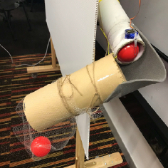 Dispensed red plastic ball caught in a small net bag of the dispensing mechanism