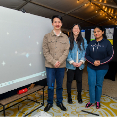 (From left to right) Jason, Michelle and Tina of Team Aequor standing next to the Galaxy Charter wall at the exhibit.