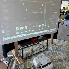 Exhibit projection setup of the Galaxy Charter, with the projector placed on the ground in front of the corflute wall